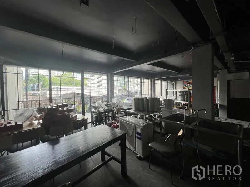 พื้นที่ขายปลีก ให้เช่าในWatthana, Bangkok - มุมมองภายในสู่ผนังกระจกสูง พร้อมอุปกรณ์จัดเก็บในพื้นที่.