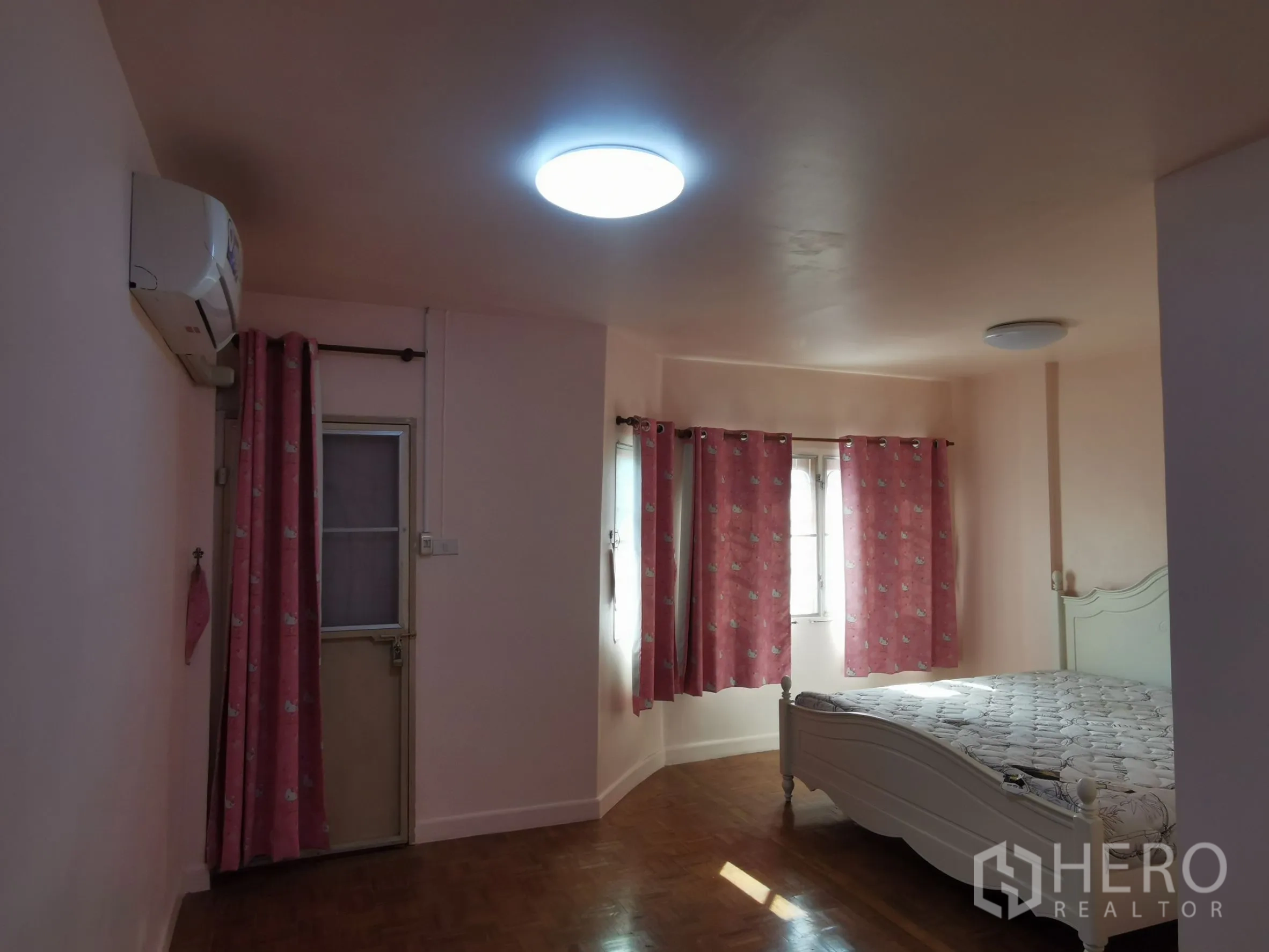 ทาวน์เฮาส์ ให้เช่าในKhlong Toei, Bangkok - ห้องนอนใหญ่มีแอร์ หน้าต่างหลายบาน และเตียงกรอบสีขาวกับผ้าม่านสีชมพู