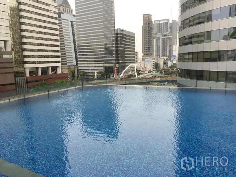 Condominium for rent or sale in Bang Rak, Bangkok - Outdoor swimming pool surrounded by high-rise buildings in central Bangkok.