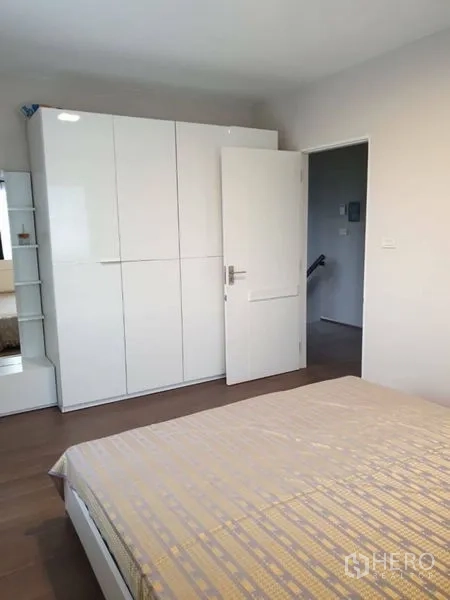 Detached House for rent in Bang Phli, Samut Prakan - Guest bedroom with wardrobe, white door and wood flooring.