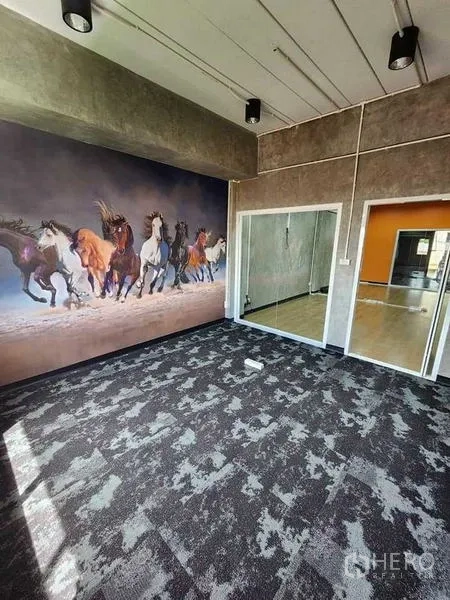 Office Space for rent or sale in Bueng Kum, Bangkok - Creative room with patterned carpet, feature wall art and glass partition connecting to adjacent office.