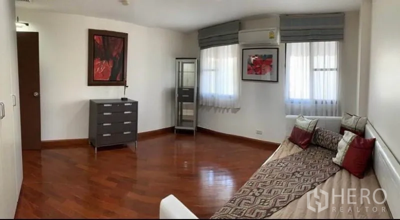 Townhouse for rent in Khlong Toei, Bangkok - Spacious third bedroom with wood floors, daybed, dresser and multiple windows.