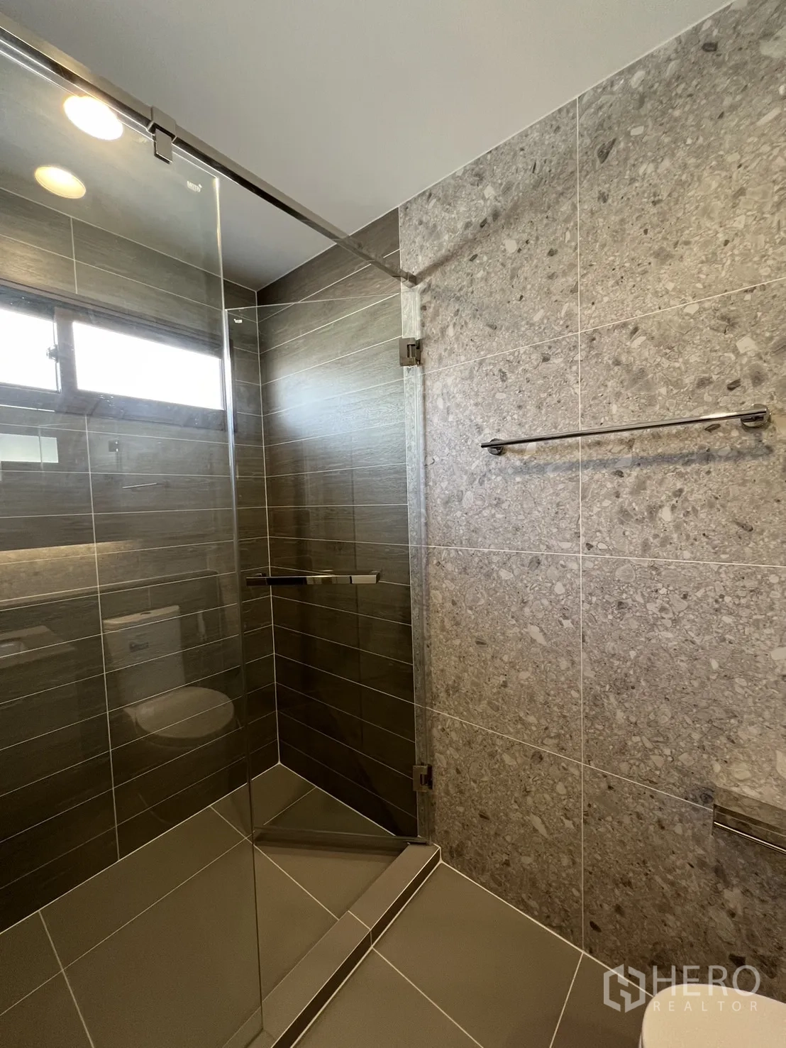 Detached House for rent or sale in Bang Kapi, Bangkok - Guest bathroom with vanity, large mirror and neutral tiles.