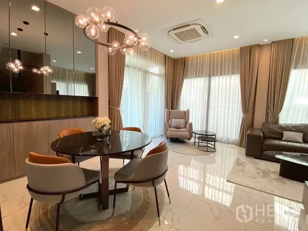 Detached House for rent in Bang Phli, Samut Prakan - Dining corner with glossy black table, designer chandelier and mirrored wall beside large windows.