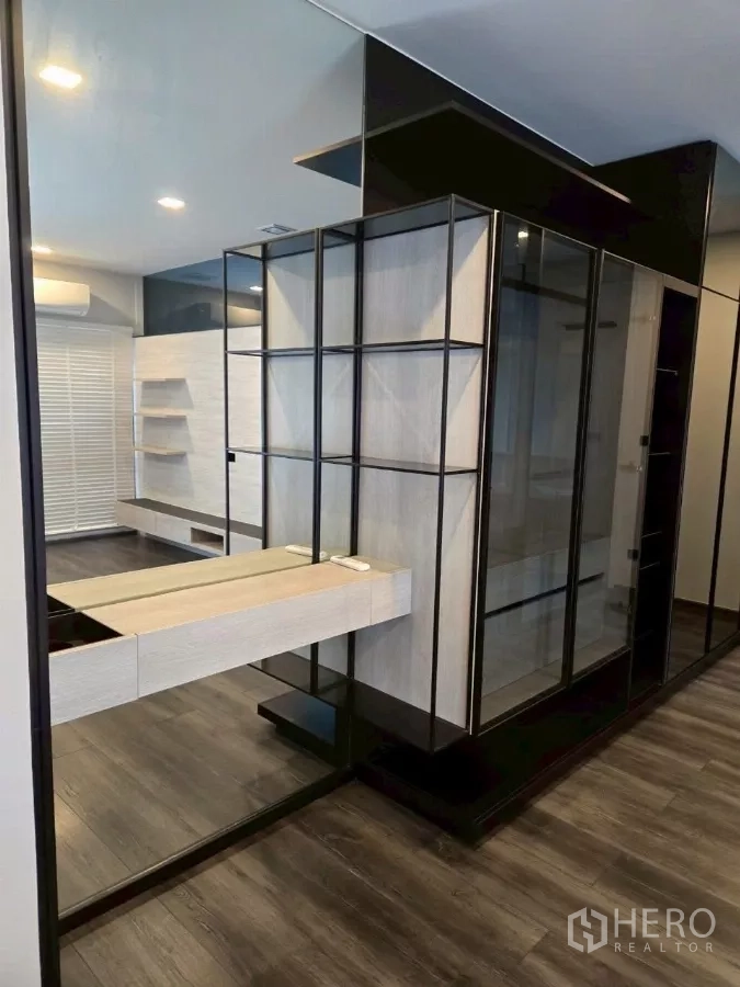 Townhouse for rent in Bang Phli, Samut Prakan - Modern walk-in closet with glass wardrobes, vanity, and mirrored wall.