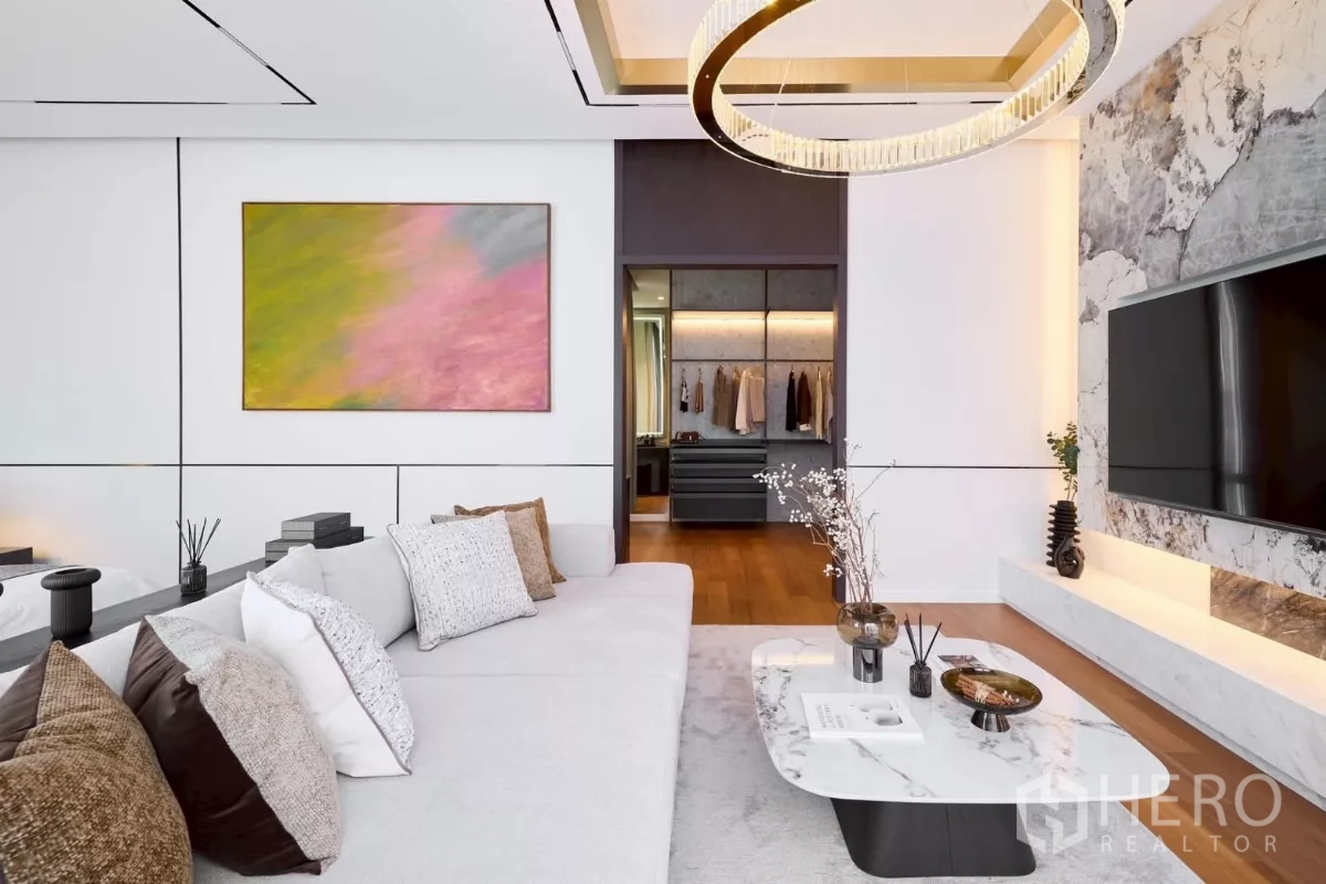 บ้าน ขายในLat Phrao, Bangkok - มุมนั่งเล่นมาสเตอร์ ผนังทีวีหินอ่อน โคมไฟวงกลม และทางเข้าห้องแต่งตัว