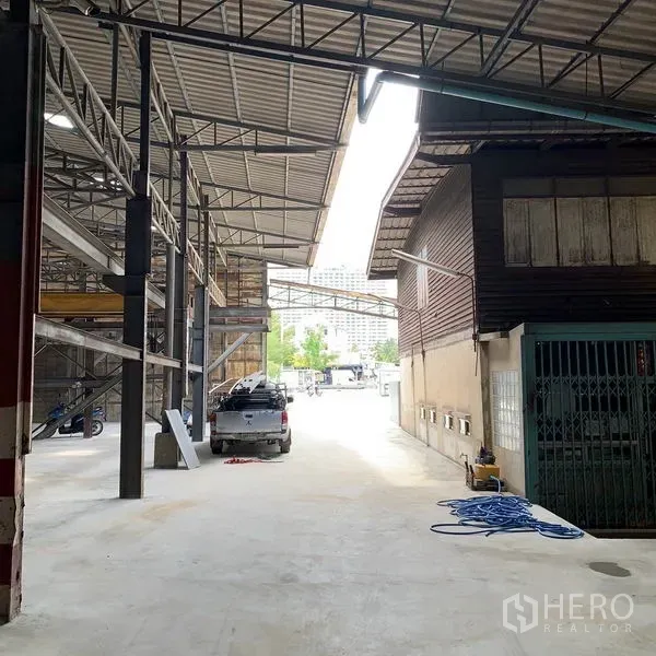 Warehouse for rent in Yan Nawa, Bangkok - Covered driveway between steel-framed warehouse and annex for vehicle loading access.