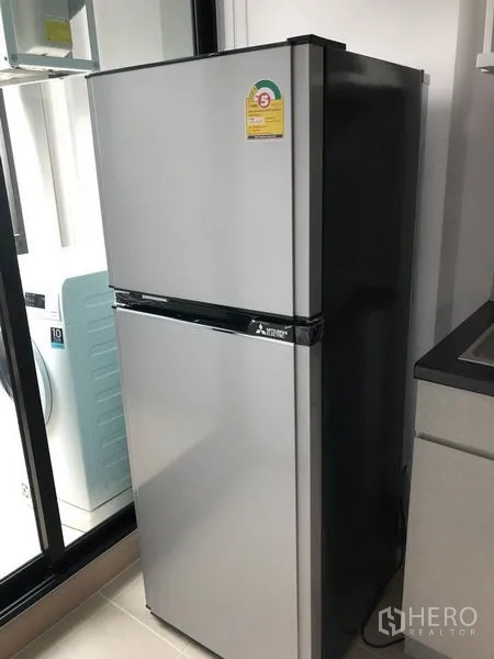 คอนโด ขายในKhlong Toei, Bangkok - ตู้เย็นสองประตูสแตนเลสวางข้างประตูระเบียงในครัว