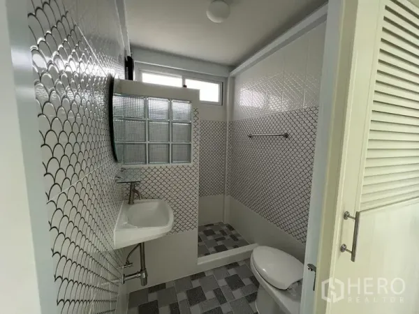 บ้าน ให้เช่าในKhlong Toei, Bangkok - ห้องน้ำกะทัดรัด กระเบื้องลายกราฟิก ฉากกั้นบล็อกแก้ว อ่างล้างมือและโถสุขภัณฑ์ ใต้หน้าต่างสูง
