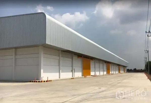 Warehouse for rent in Phra Nakhon Si Ayutthaya - Modern warehouse exterior with multiple loading bays and a wide concrete truck yard.