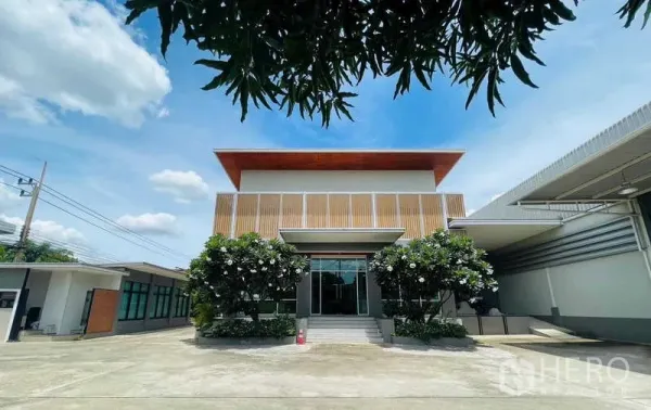 工厂 出售在Krathum Baen, Samut Sakhon - 办公楼正立面，玻璃入口与台阶，配鸡蛋花景观