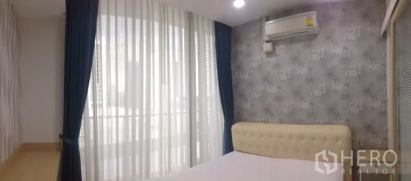 คอนโด ให้เช่าในPhaya Thai, Bangkok - ห้องนอนอบอุ่น เตียงหุ้มผ้า วอลเปเปอร์ลายดอก และผ้าม่านสูงจรดเพดาน