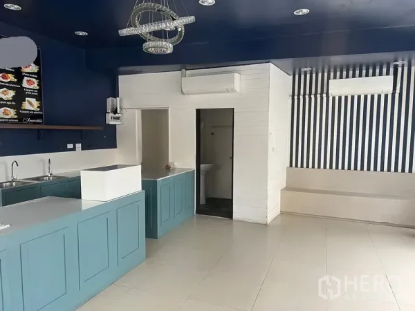 零售空间 出租在Watthana, Bangkok - 开放式零售区域，展示吧台、空调与通往卫生间的门。