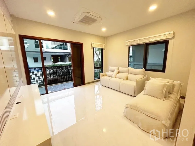 Detached House for rent in Bang Phli, Samut Prakan - Living room with white sofas opening to a patio via sliding doors.