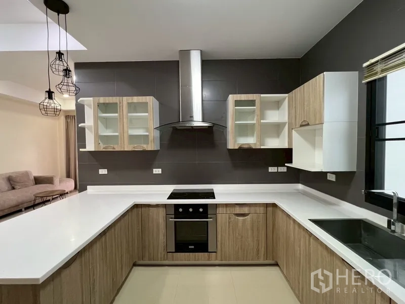 บ้าน ขายในPhra Khanong, Bangkok - ครัวรูปตัว U ท็อปสีขาว พร้อมเตาอบ เตาไฟฟ้า และเครื่องดูดควันสแตนเลส