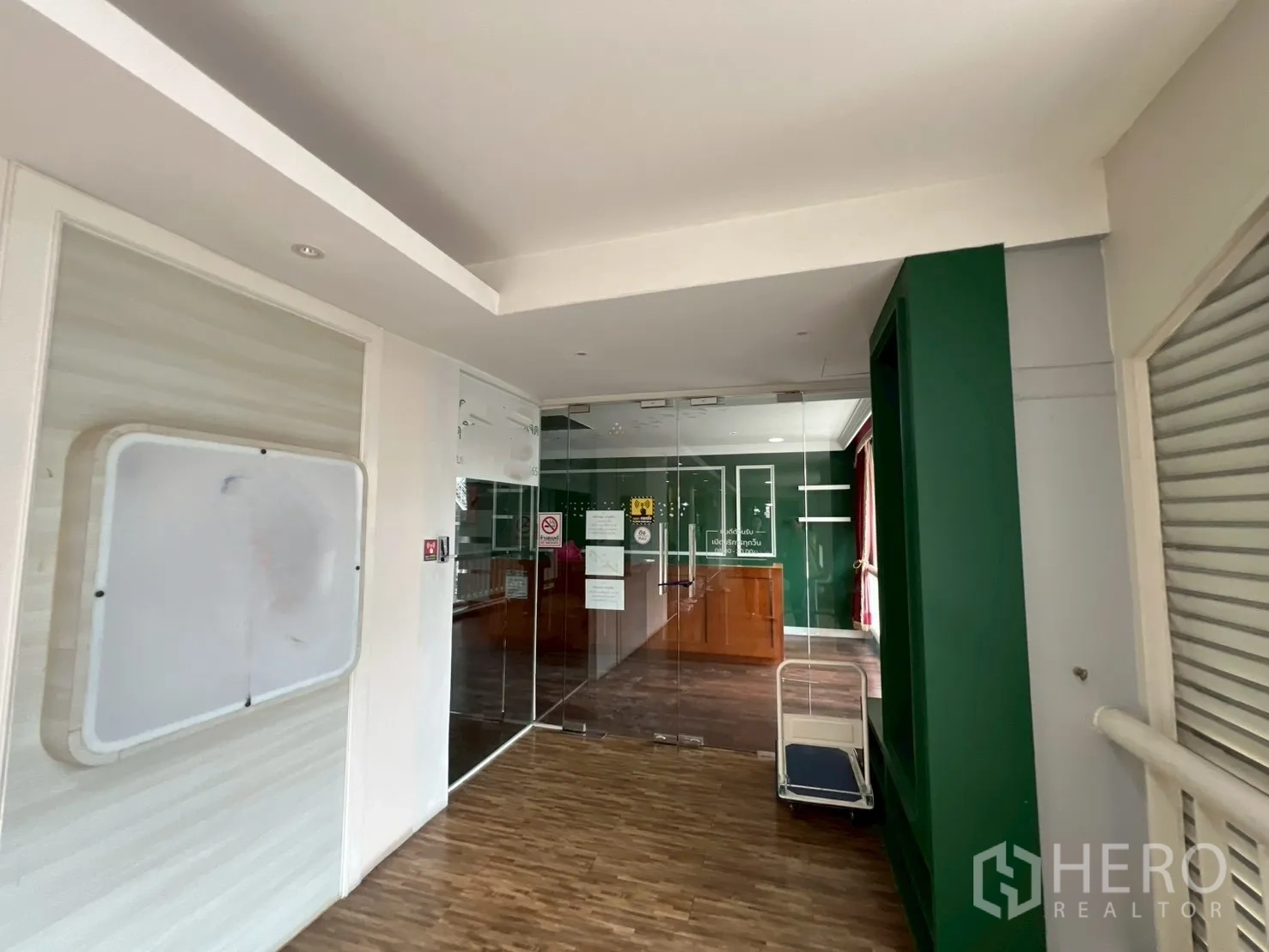Office Space for rent in Watthana, Bangkok - Building corridor outside the unit showing the glass entrance and lobby-style approach.