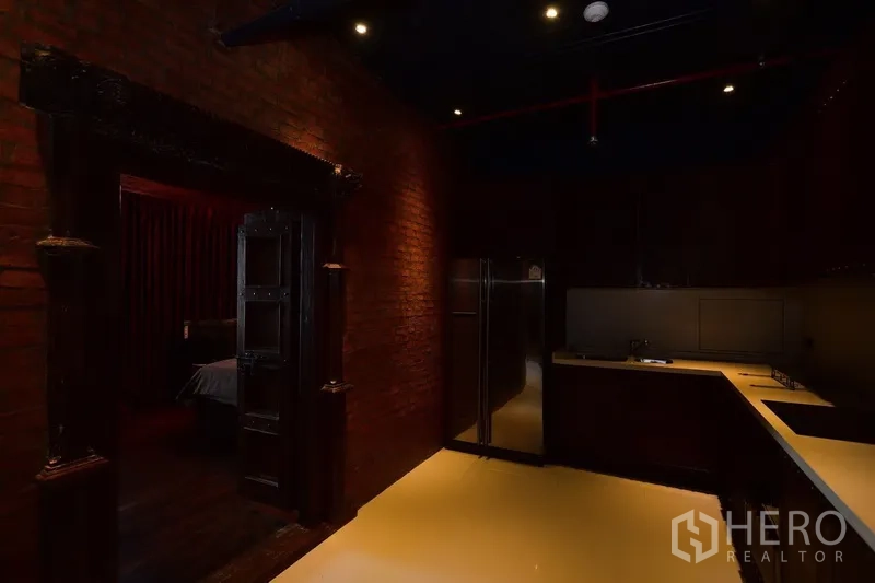 คอนโด ให้เช่าหรือขายในKhlong Toei, Bangkok - ครัวรูปตัวแอล ตู้สีเข้ม ตู้เย็นสแตนเลส และผนังอิฐโชว์แนว