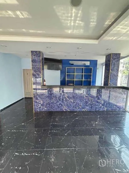 零售空间 出租在Khlong Toei, Bangkok - 前场柜台区，大理石纹包饰与天花筒灯。