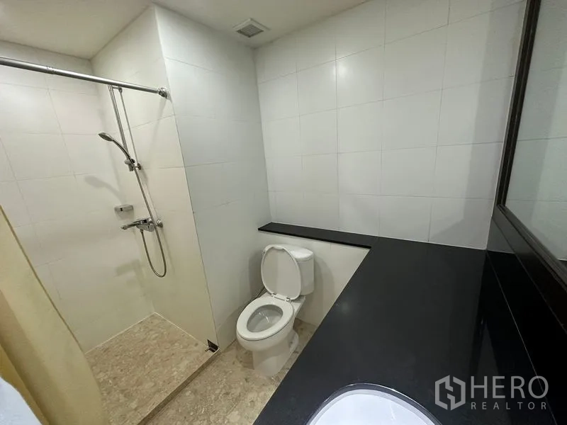 คอนโด ให้เช่าในWatthana, Bangkok - ห้องน้ำพร้อมโซนฝักบัวแบบวอล์กอิน กระเบื้องสีขาว โถสุขภัณฑ์ และเคาน์เตอร์ยาว