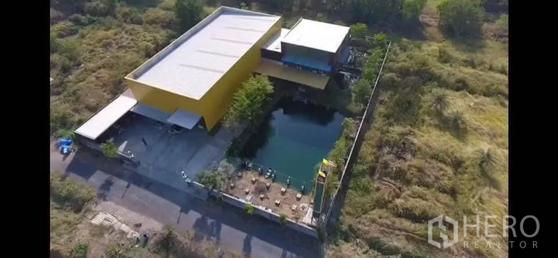 โรงงาน ขายในThanyaburi, Pathum Thani - ภาพมุมสูงของพื้นที่โรงงาน มีโกดัง ลานจอด และสระน้ำขนาดใหญ่ภายในรั้ว