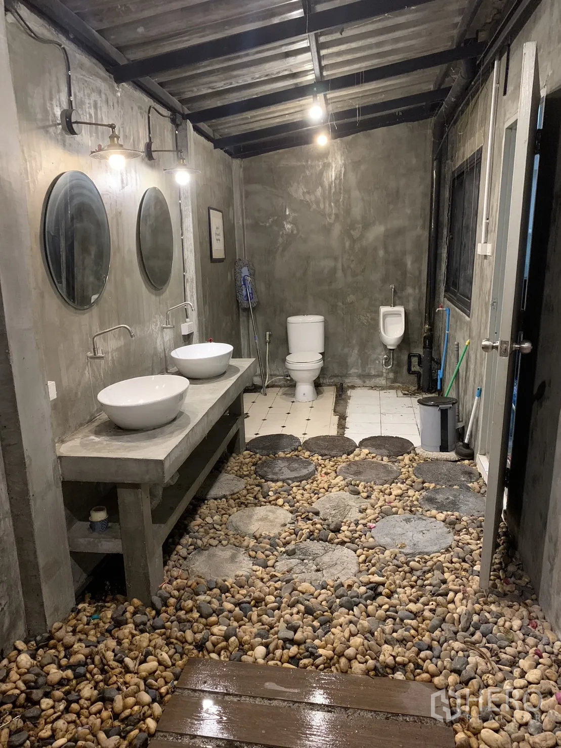 联排别墅 出租在Watthana, Bangkok - 工业风卫生间，卵石地面、双台盆与裸露天花。