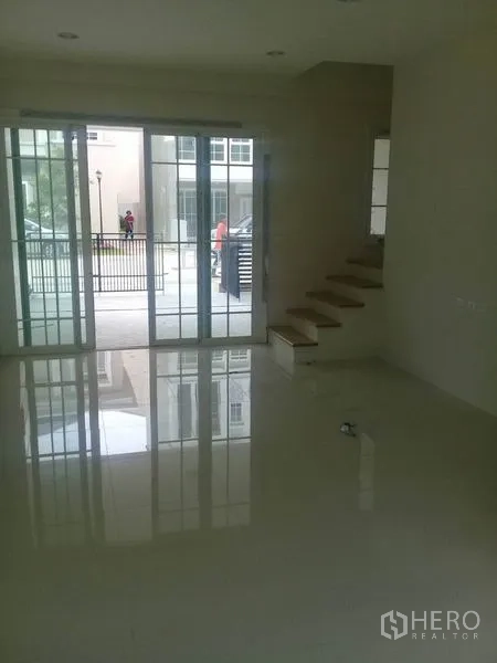 สำนักงานที่บ้าน ให้เช่าในBang Na, Bangkok - พื้นที่ชั้นล่างสว่าง ปูพื้นกระเบื้องเงา ประตูกระจกบานเลื่อนขนาดใหญ่และบันไดขึ้นชั้นบน