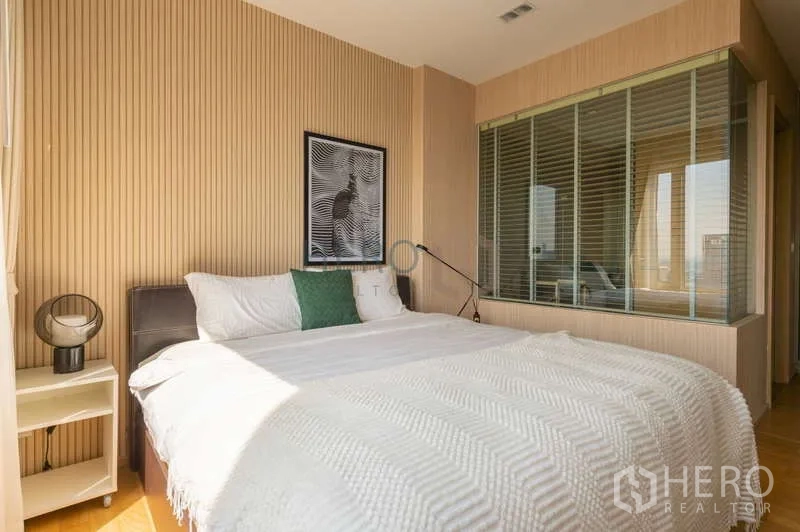 Condominium for sale in Khlong Toei, Bangkok - Master bedroom with glass partition to the bathroom and abundant natural light.