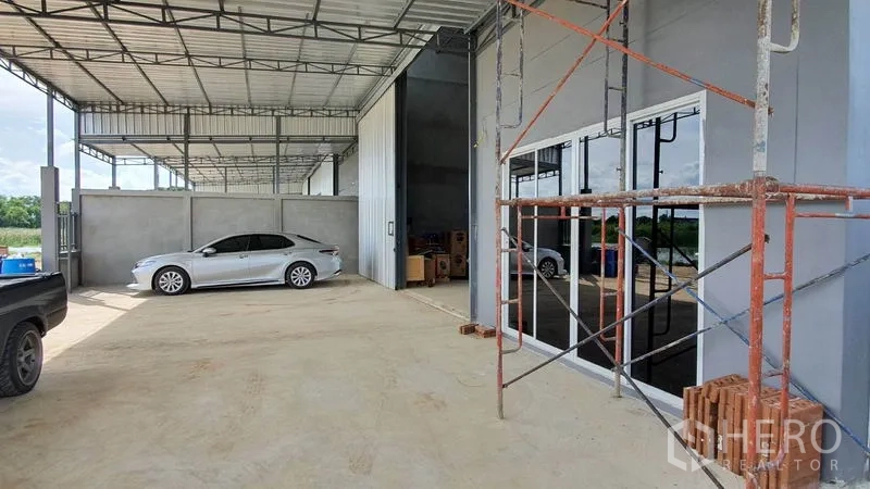 คลังสินค้า ให้เช่าในLam Luk Ka, Pathum Thani - ลานโหลดของมีหลังคา ข้างออฟฟิศกั้นกระจกและประตูเข้าโกดังสูง