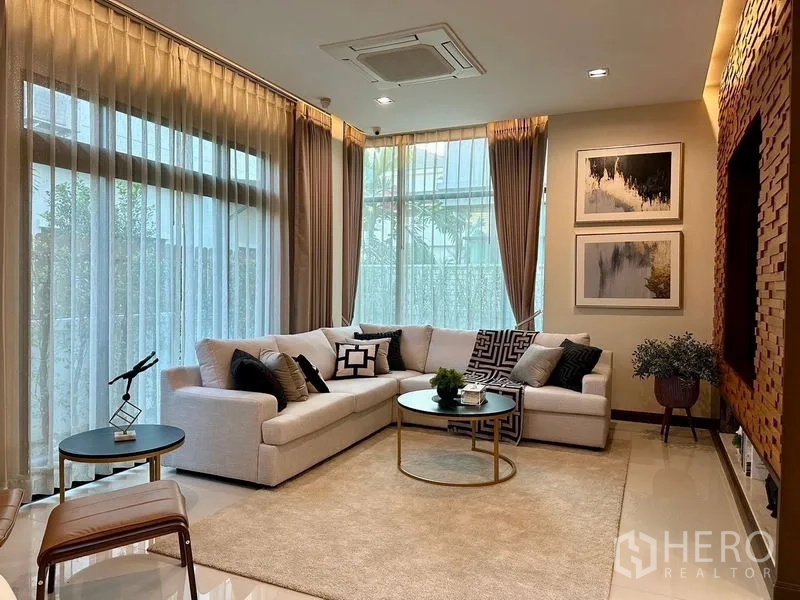 独立式住宅 出租 - 采光充足的家庭客厅，白色转角沙发与大面积落地窗。