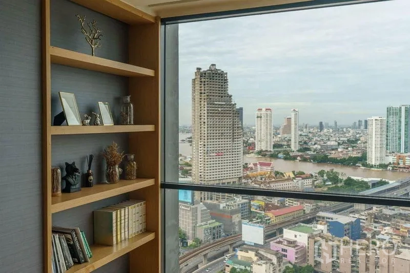 คอนโด ให้เช่าหรือขายในBang Rak, Bangkok - ชั้นวางไม้บิลต์อินข้างหน้าต่างกระจกเต็มบาน พร้อมวิวแม่น้ำเจ้าพระยาและตึกสูงของบางรัก