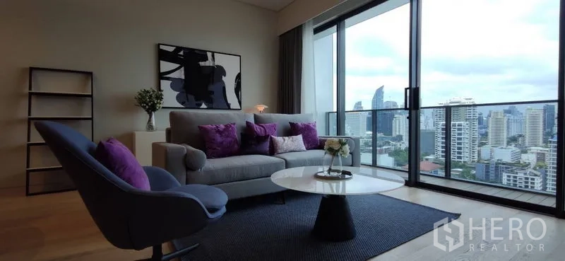 คอนโด ให้เช่าหรือขายในWatthana, Bangkok - ห้องนั่งเล่นเปิดออกสู่ระเบียง เห็นวิวสกายไลน์ พร้อมโต๊ะกาแฟ