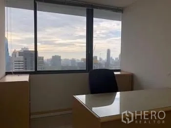 Office Space for rent or sale - Private executive desk by a large window with Bangkok skyline views.