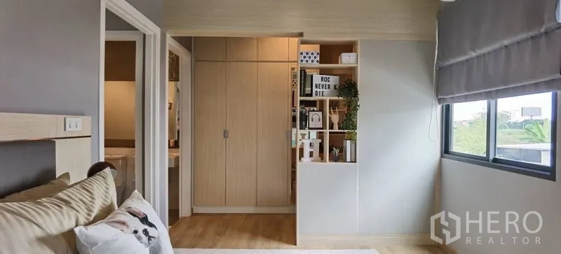 联排别墅 出租在Prawet, Bangkok - 卧室带内置衣柜、开放格架及带百叶的大窗。