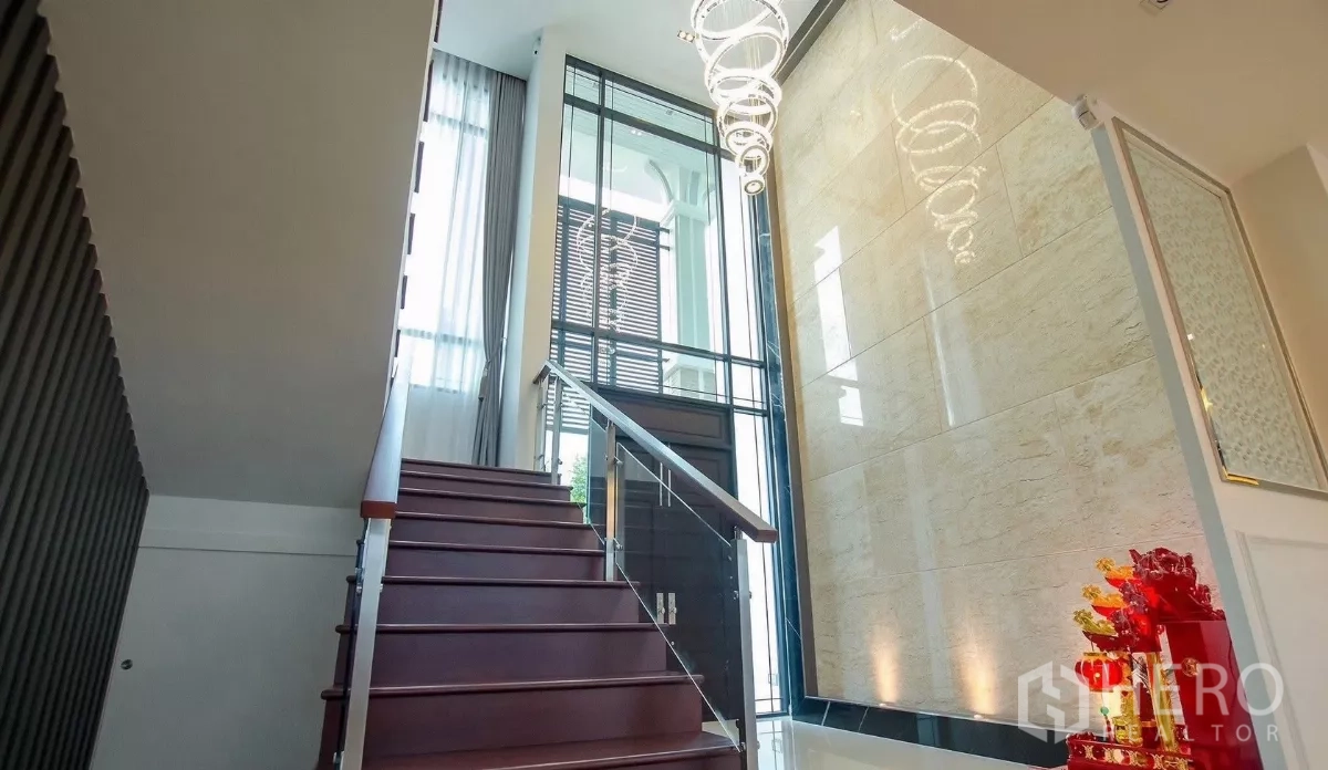Detached House for rent in Bang Bon, Bangkok - Grand staircase with glass railing, tall windows and pendant lights at the foyer.