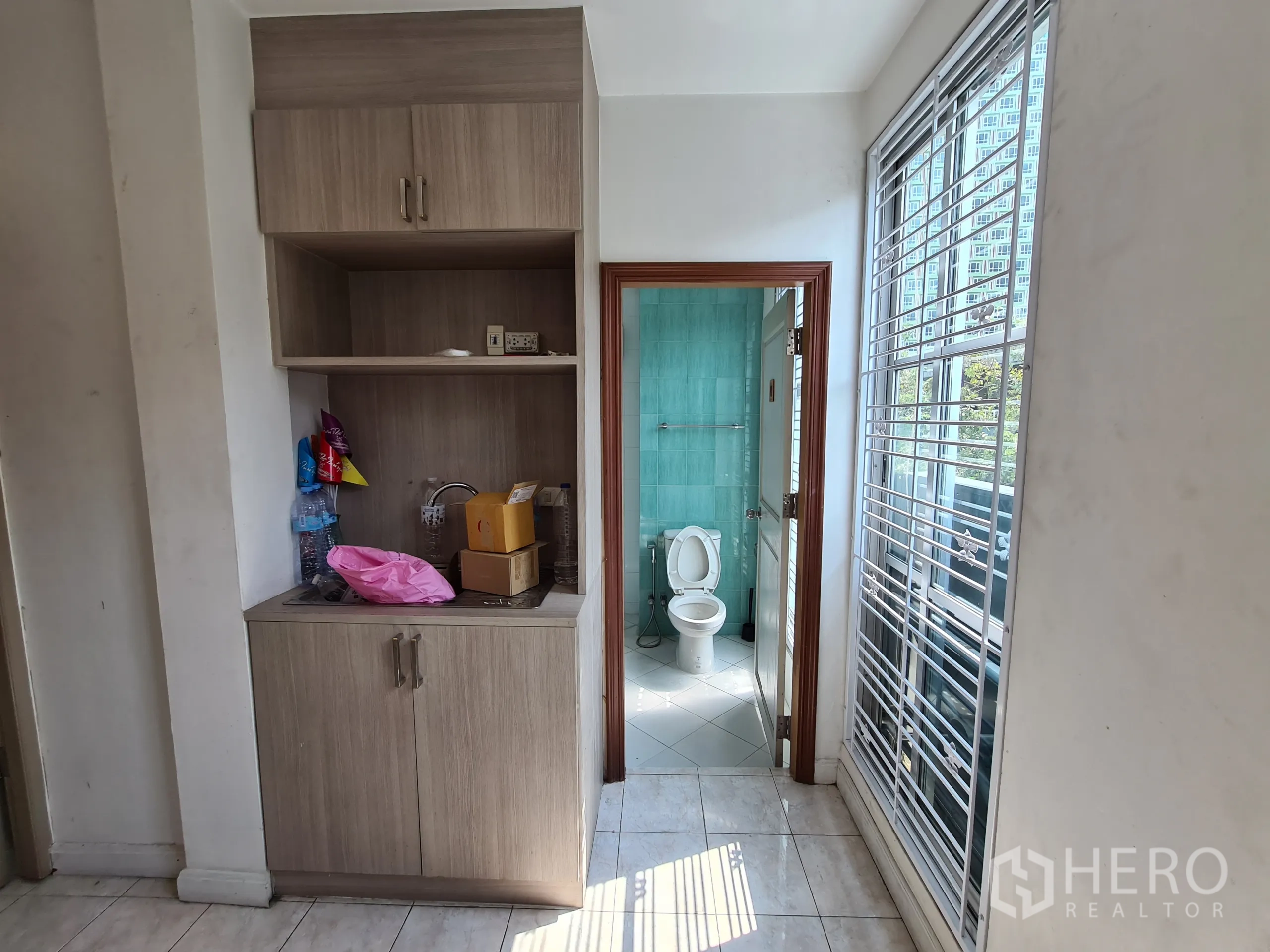 店屋 出租或出售在Sathon, Bangkok - 紧凑茶水柜，旁为瓷砖卫生间与高窗护栏。