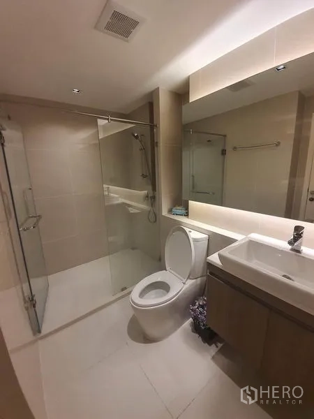 公寓 出租在Khlong Toei, Bangkok - 当代风卫浴，玻璃干湿分离淋浴间、坐便与洗手台。