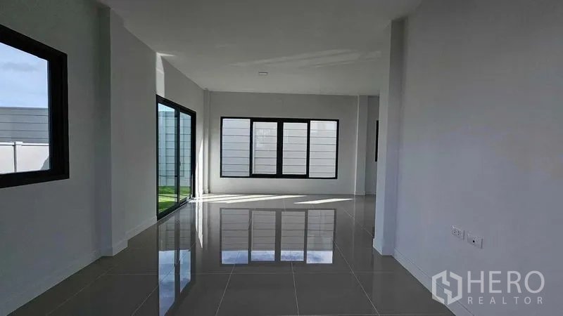 Detached House for sale in Samut Prakan - Staircase detail with wooden handrail and black metal balustrade.