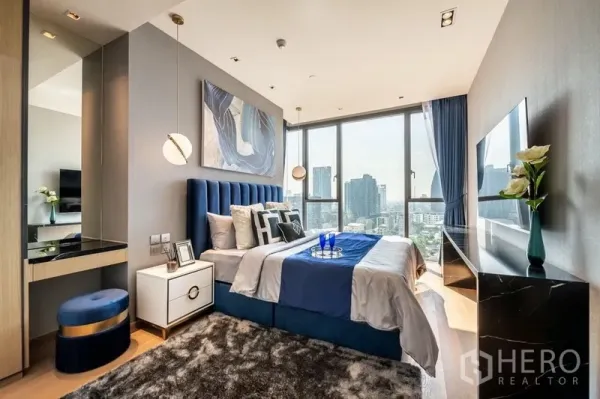 คอนโด ให้เช่าหรือขายในKhlong Toei, Bangkok - ห้องนอนใหญ่หัวเตียงกำมะหยี่สีน้ำเงิน โคมแขวน หน้าต่างบานสูงและวิวเมืองกว้าง