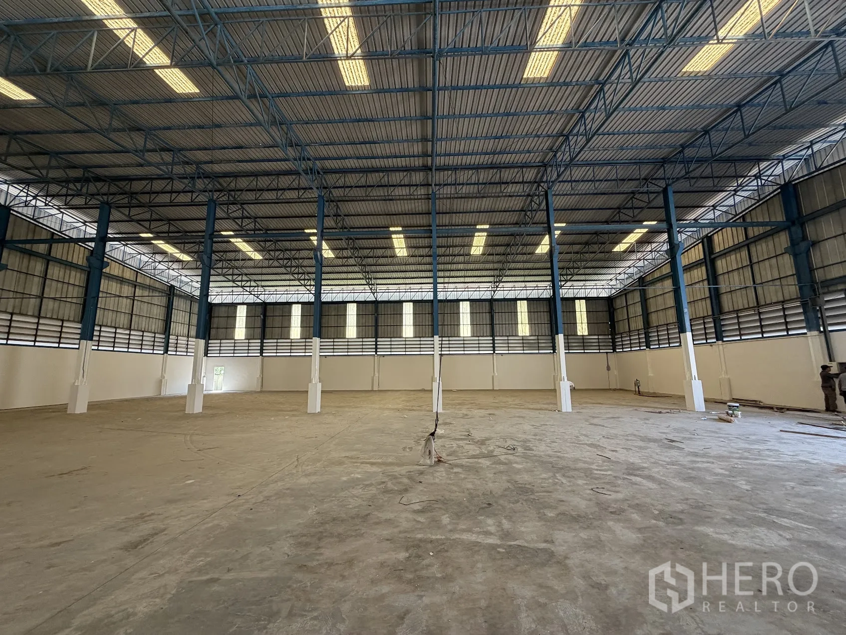 Factory for rent in Bang Sao Thong, Samut Prakan - Symmetrical view of the expansive warehouse hall with multiple steel columns and overhead lighting.