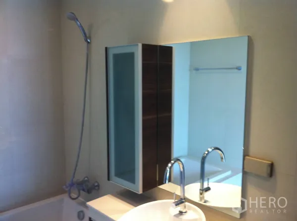 公寓 出租在Watthana, Bangkok - 现代卫浴配浴缸与手持花洒、台上盆、大镜面及收纳柜。