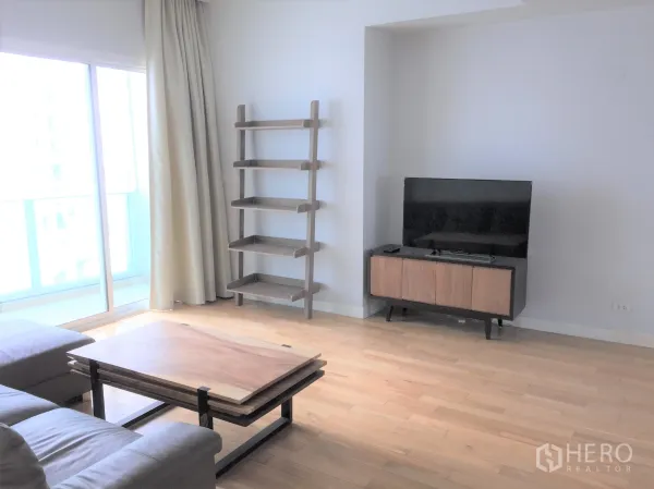 คอนโด ให้เช่าหรือขายในKhlong Toei, Bangkok - มุมทีวีพร้อมตู้วางสื่อ ชั้นวางของ และประตูกระจกบานเลื่อนออกสู่ระเบียง