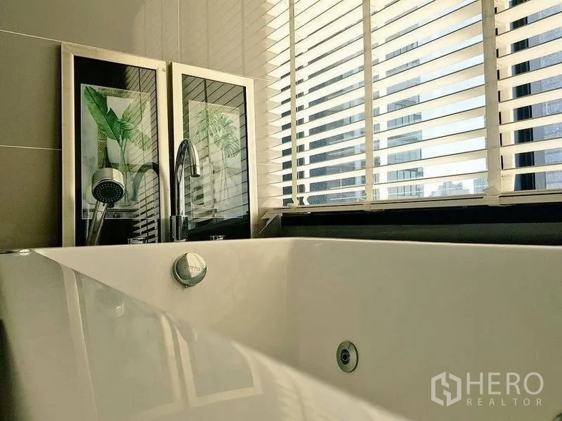 公寓 出售在Bang Rak, Bangkok - 带深浸浴缸与手持花洒的浴室，百叶窗采光。