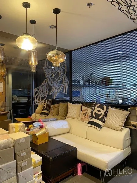 สำนักงาน ให้เช่าในPhaya Thai, Bangkok - โซนรับรองพร้อมโซฟาสีครีม โคมไฟแขวน และฉากกระจกตาข่ายในออฟฟิศสมัยใหม่