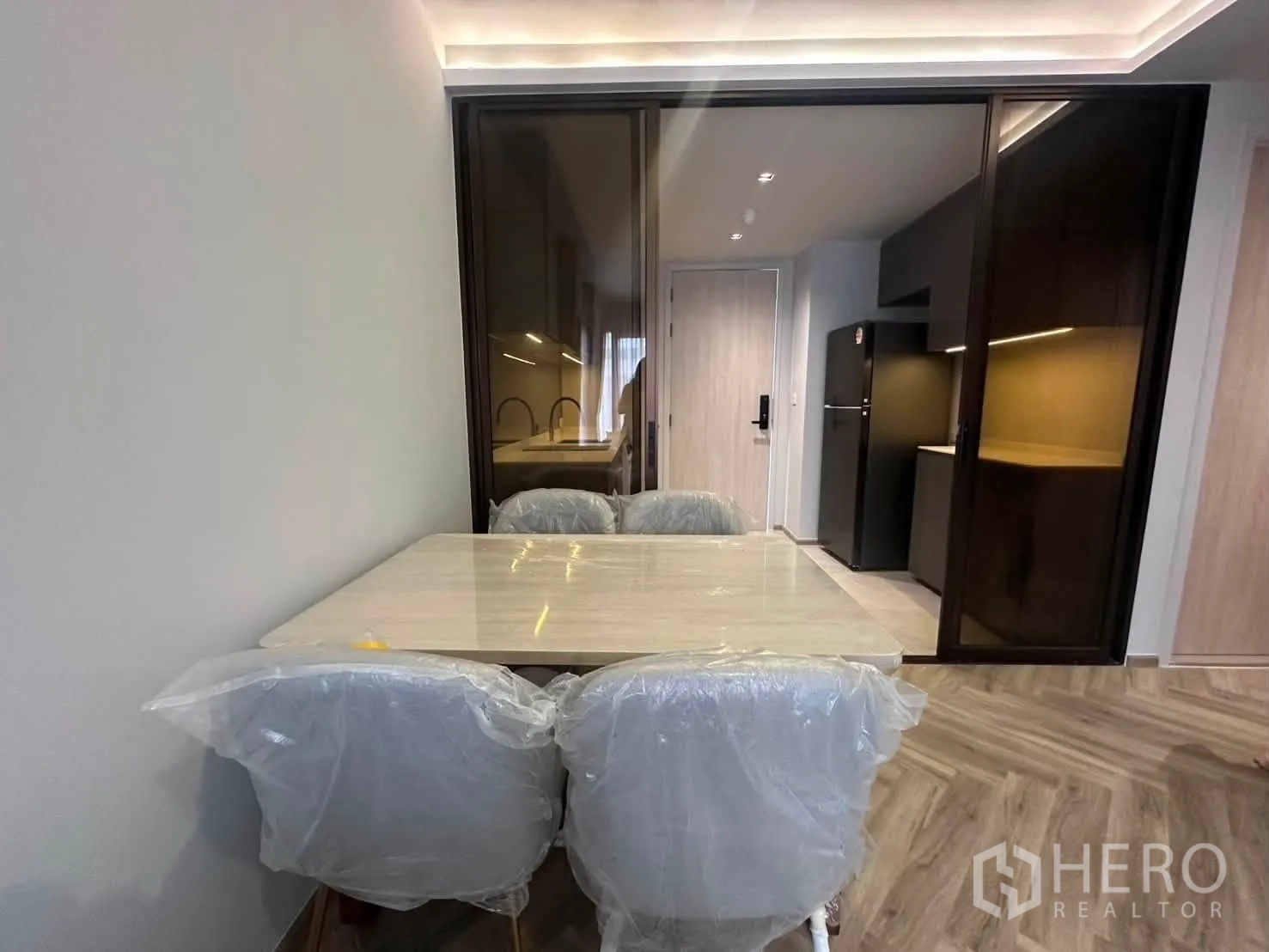 คอนโด for rent in Watthana, Bangkok - มุมรับประทานอาหารพร้อมโต๊ะและเก้าอี้ติดประตูเลื่อนกระจกไปยังครัว