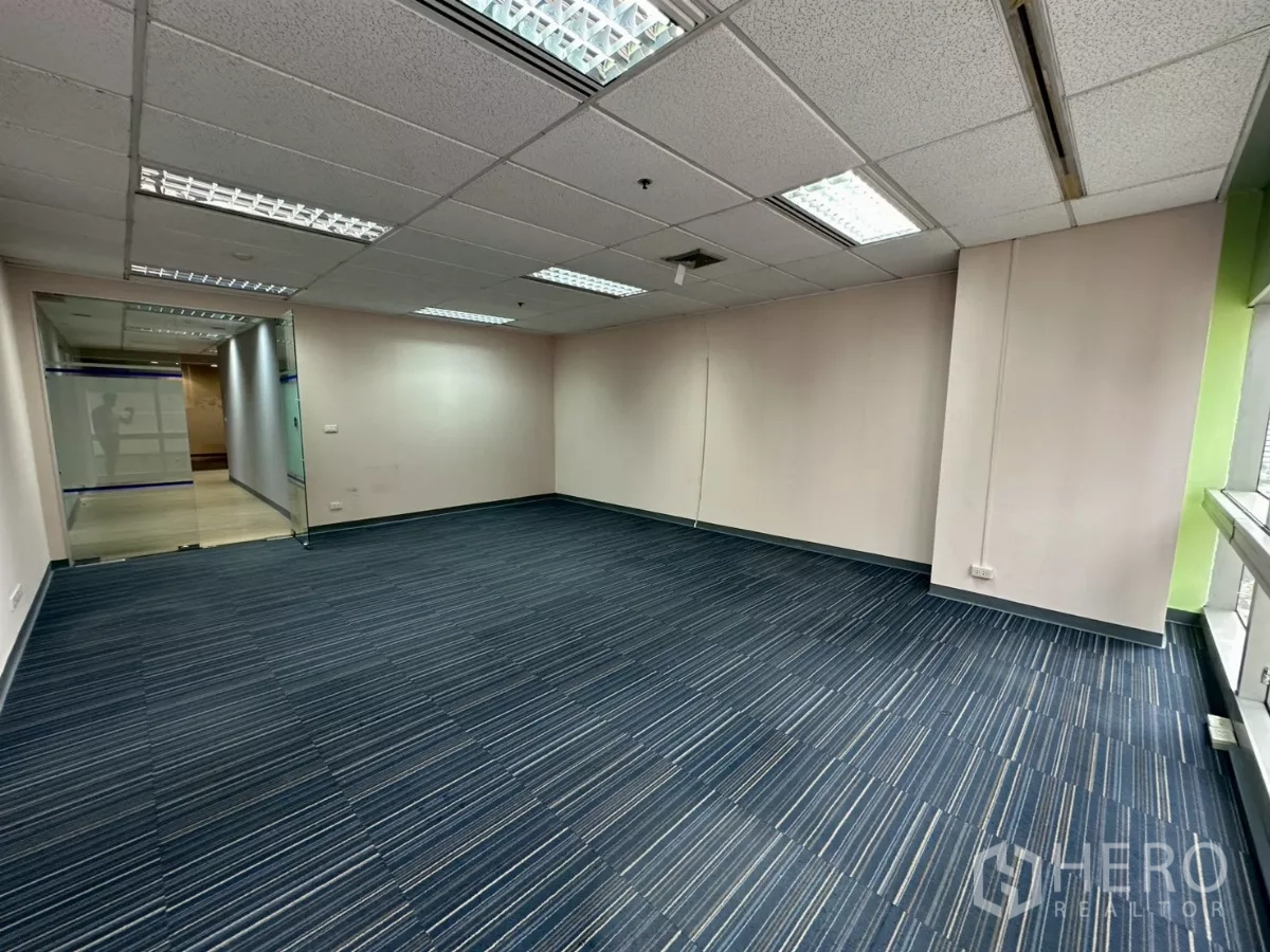 Office Space for rent in Watthana, Bangkok - Open workspace with light wood floors, large window and suspended ceiling.
