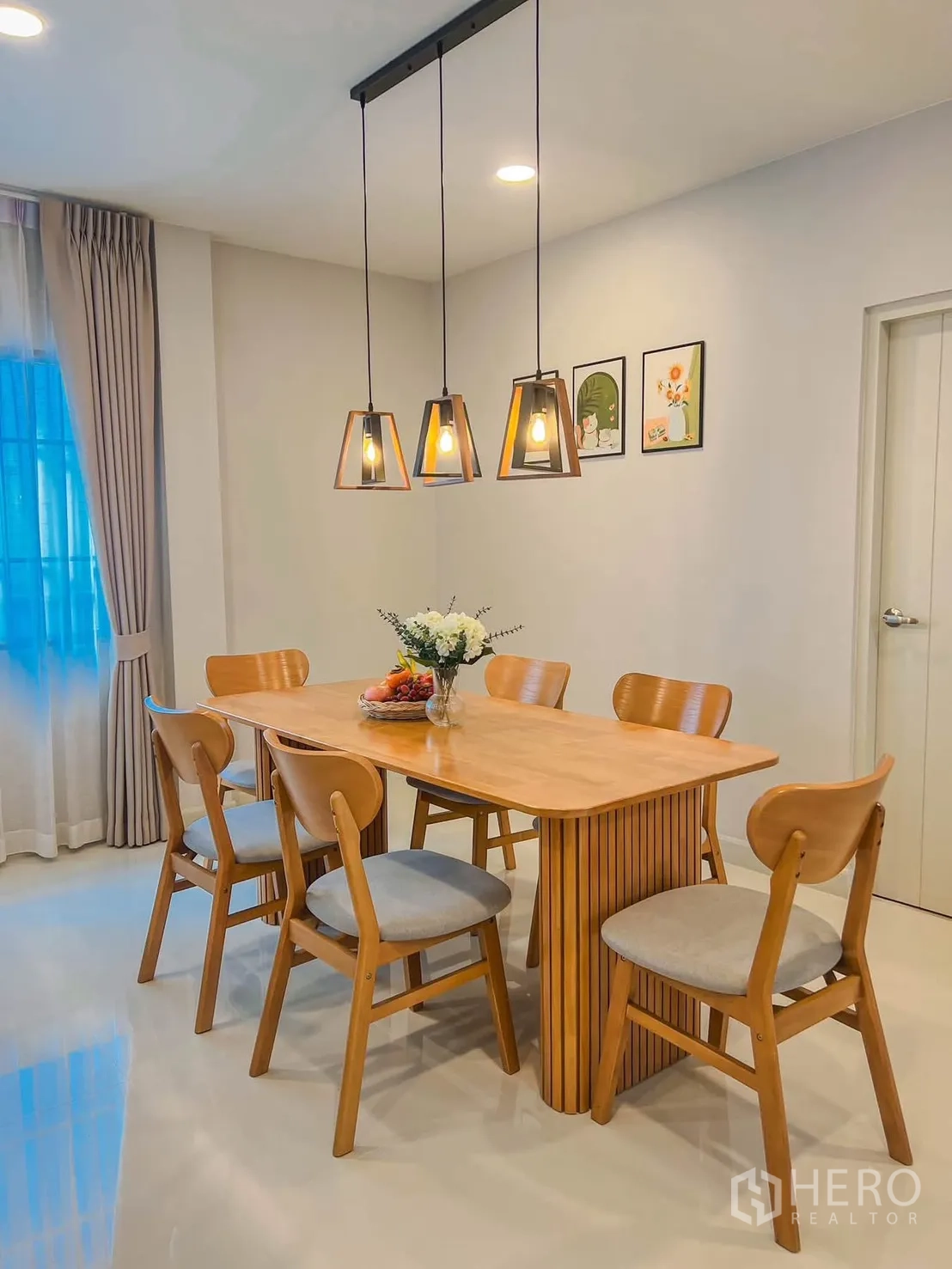 独栋房屋 for rent in Bang Phli, Samut Prakan - 餐厅全景，三盏吊灯、木桌与墙面装饰画。