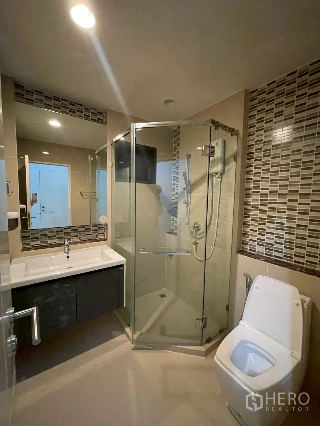 Detached House for rent in Bang Kapi, Bangkok - Another view of the bathroom highlighting the glass shower and basin cabinet.