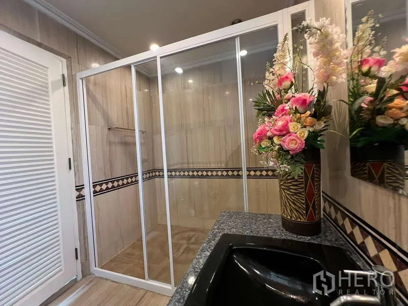 Detached House for rent in Bang Phli, Samut Prakan - Bathroom with glass shower enclosure, granite counter, and floral décor.