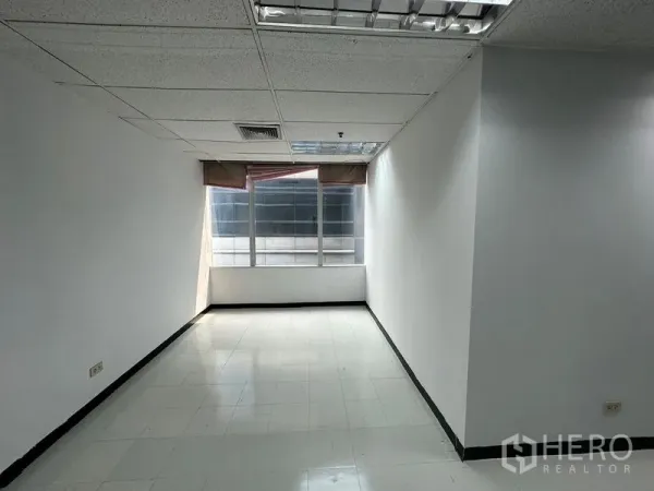 สำนักงาน ให้เช่าในChatuchak, Bangkok - มุมห้องทำงานยาวพร้อมหน้าต่างบานใหญ่ ม่านบังแสง พื้นกระเบื้อง และไฟฝังฝ้า ในอาคารสำนักงานกรุงเทพฯ