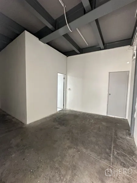Office Space for rent in Khlong Toei, Bangkok - Open office zone with two internal doors, concrete flooring and industrial ceiling lighting.